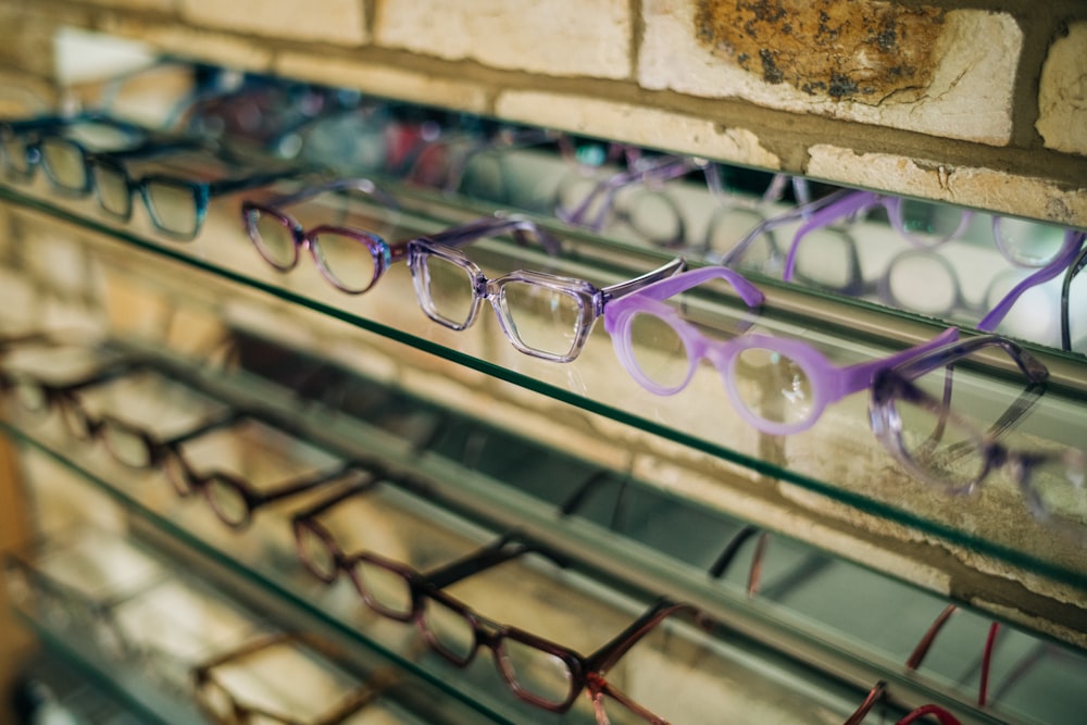 a row of glasses sitting on top of a glass shelf