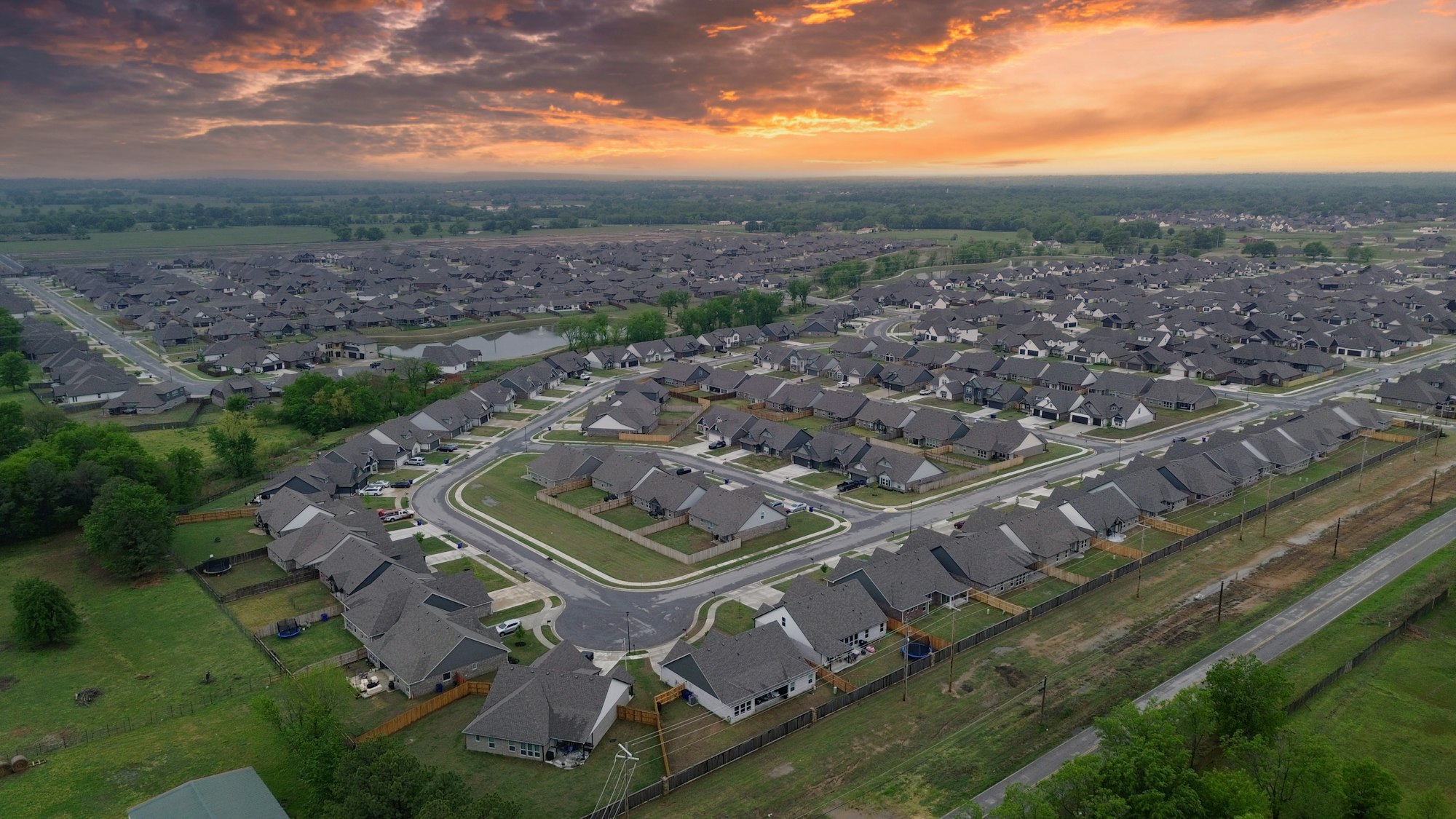 Aerial view of a new-construction subdivision at sunset outside Houston