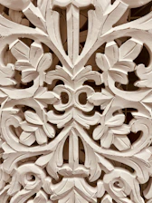 Master artisan delicately carving intricate patterns on rich sheesham wood.
