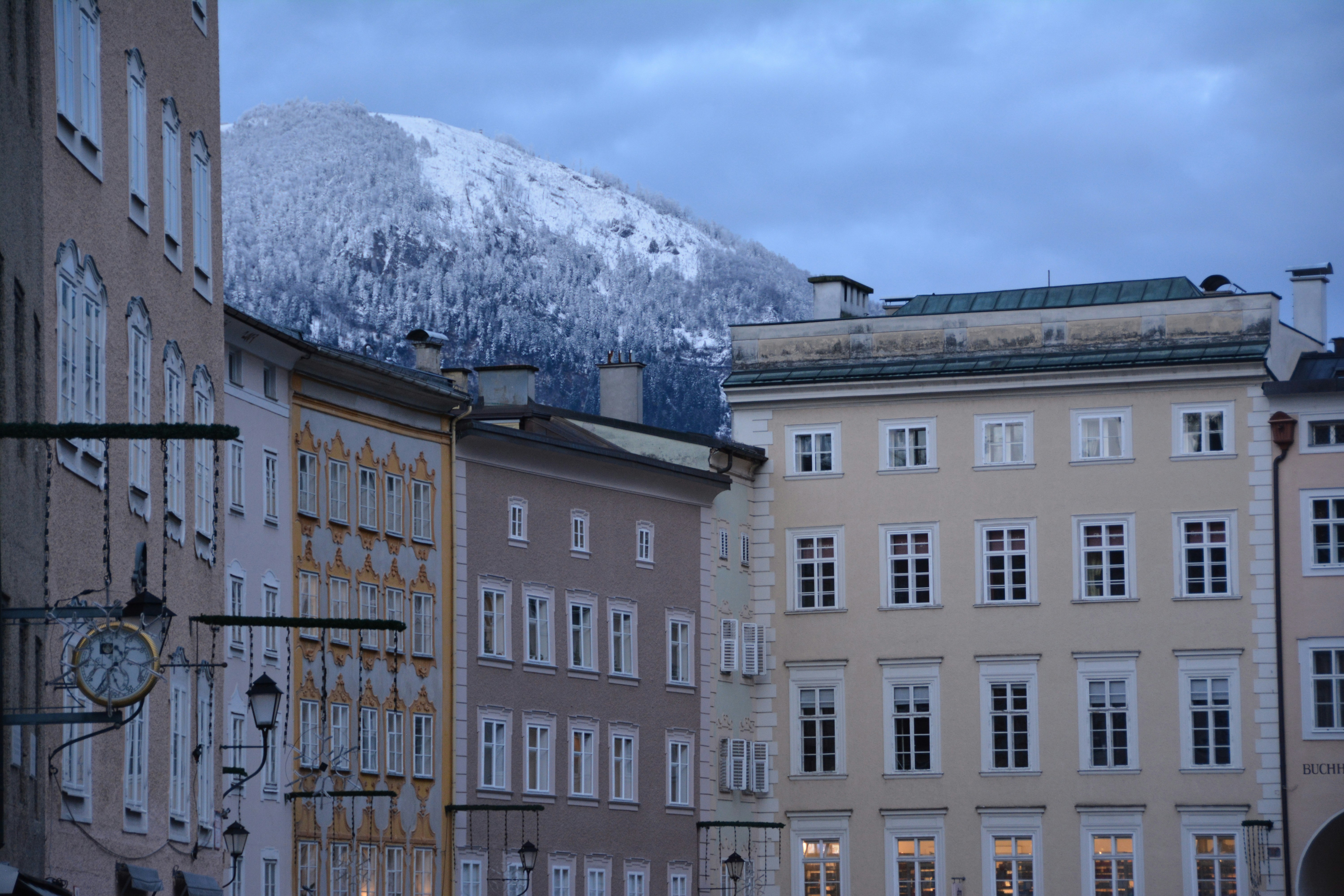 a group of buildings with a mountain in the background, Salzburg