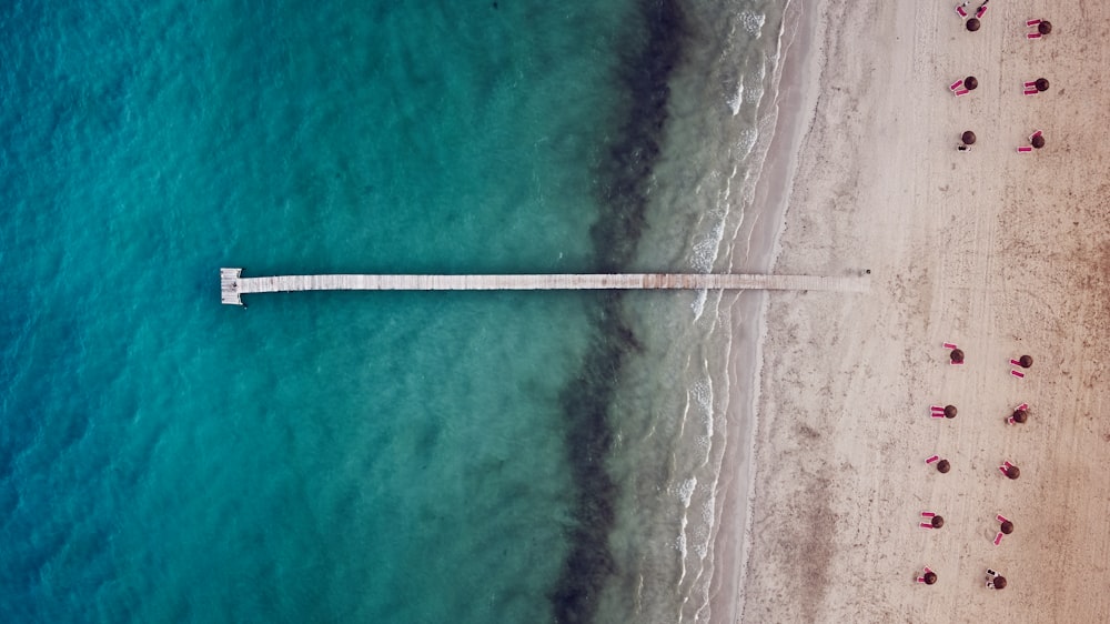 an aerial view of a beach with a pier