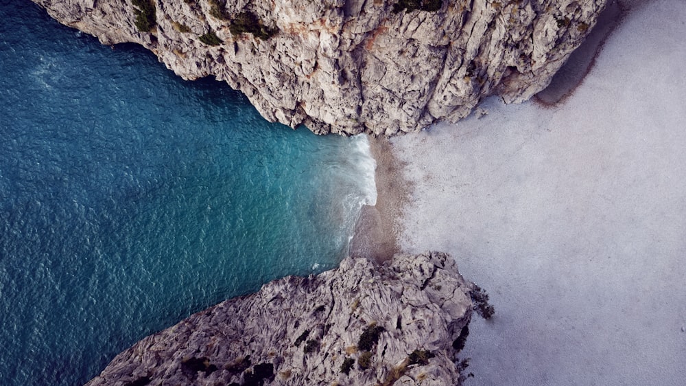 an aerial view of a rocky beach and a body of water