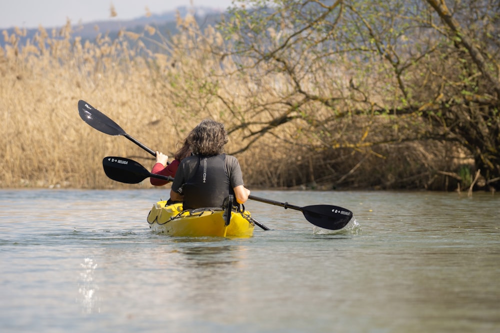 a person in a kayak paddling down a river