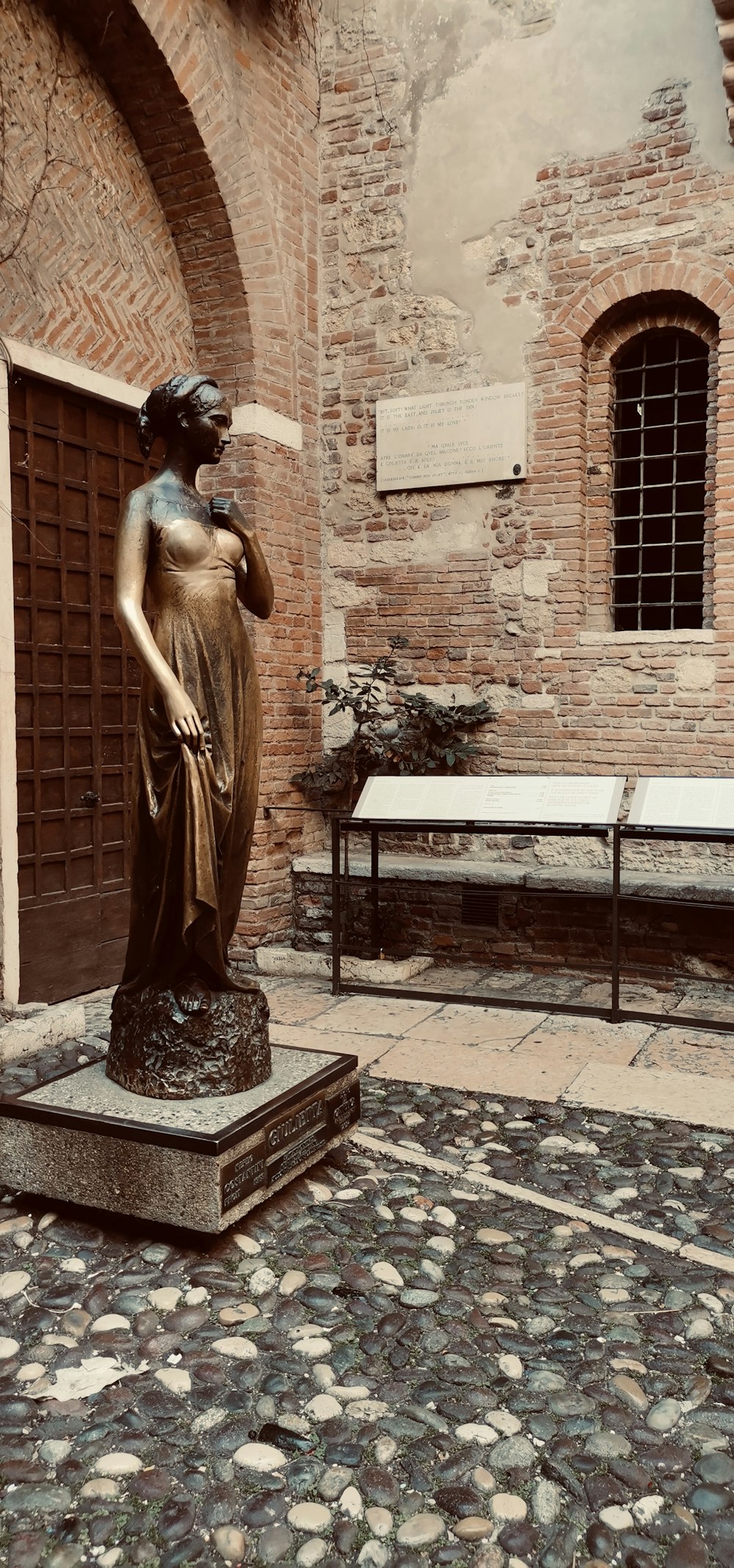 a statue of a woman standing in front of a building