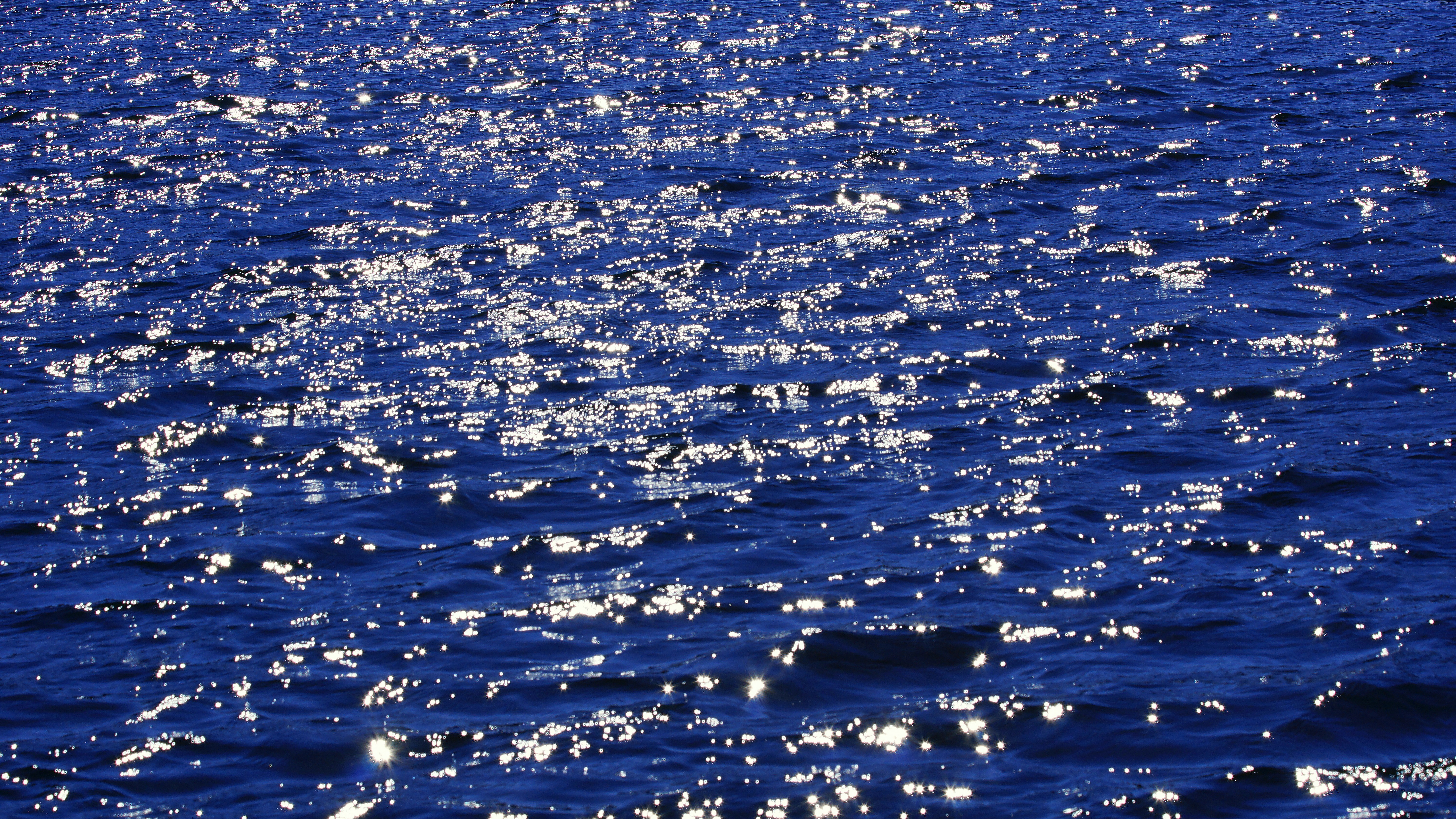 the water is very blue and the sun is shining on it