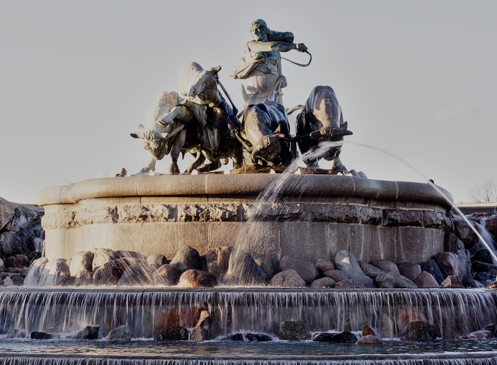 une fontaine avec une statue d’un homme à cheval