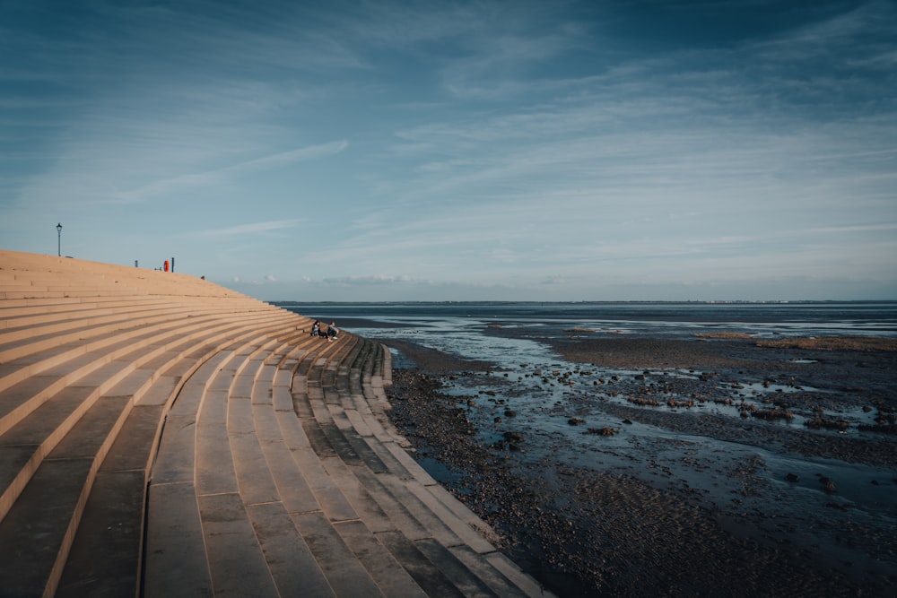 eine Person, die an einem Strand neben dem Meer spazieren geht