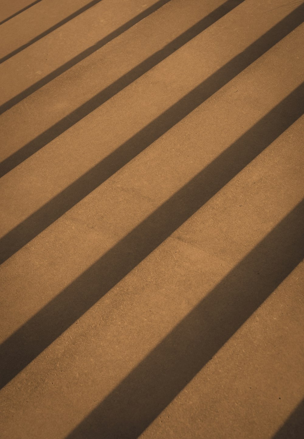 the shadow of a bench on the ground