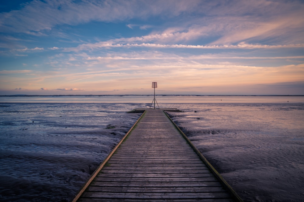 a long wooden pier extending into the ocean