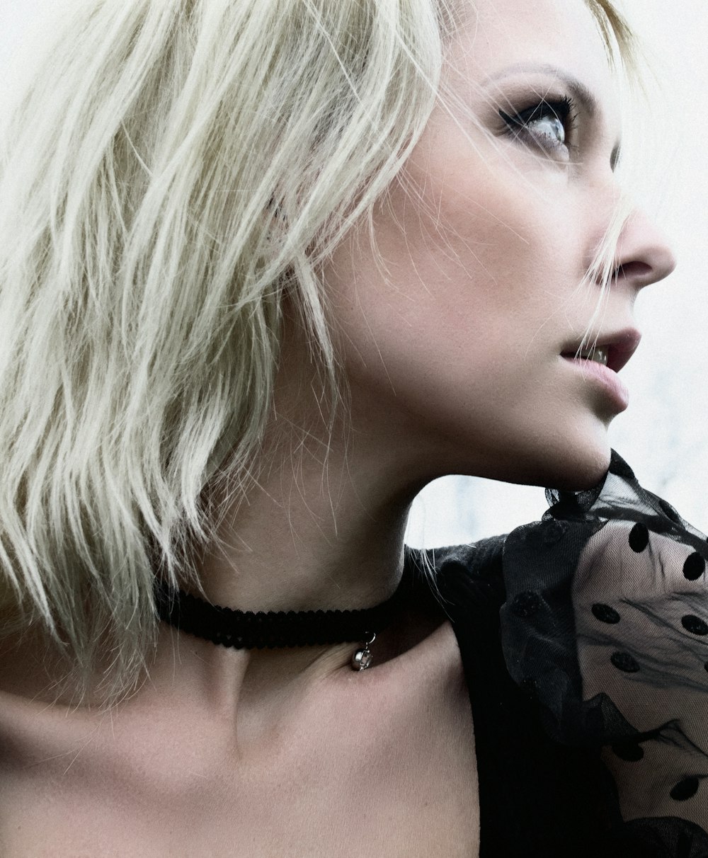 a woman with blonde hair wearing a choker