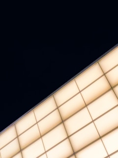 Softly illuminated geometric shapes arranged in a clean, modern pattern on a dark background.