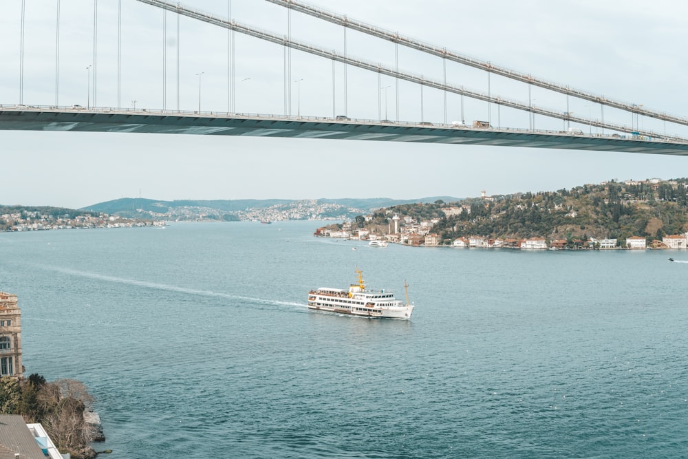 a boat traveling under a bridge on a body of water