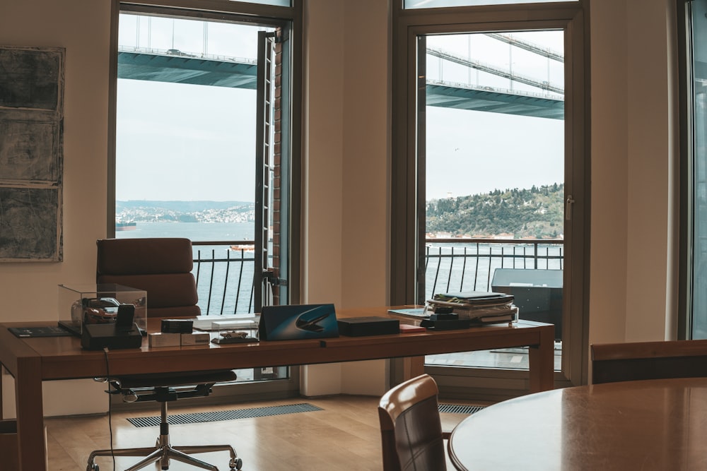 a room with a table, chairs, and a view of a body of water