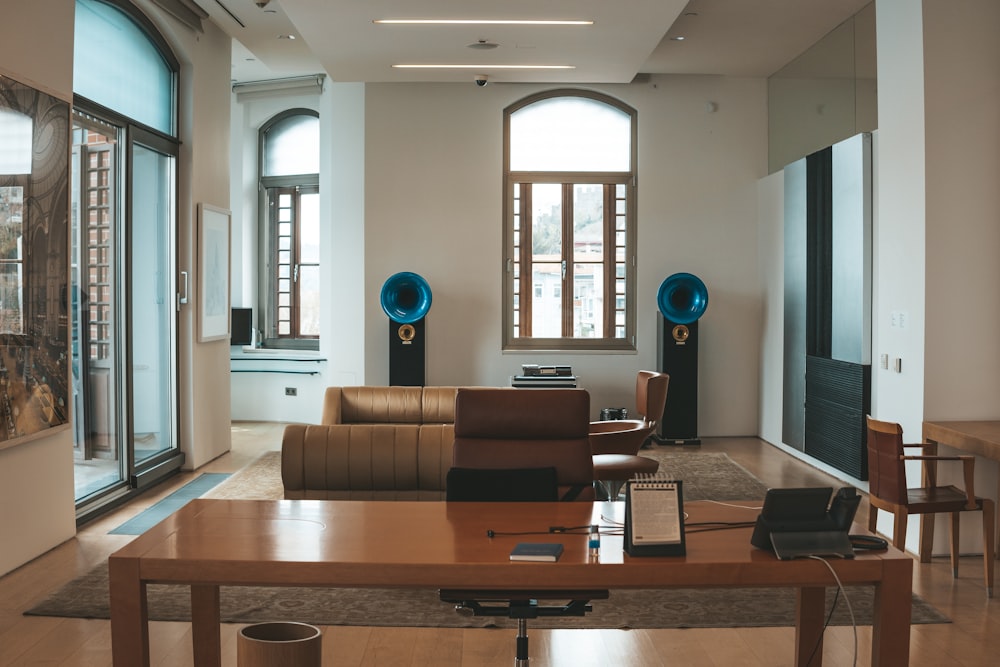 a room with a table, chairs, speakers and a couch