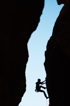 a man climbing up the side of a mountain