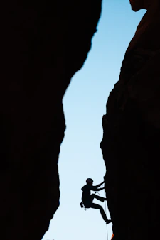 a man climbing up the side of a mountain