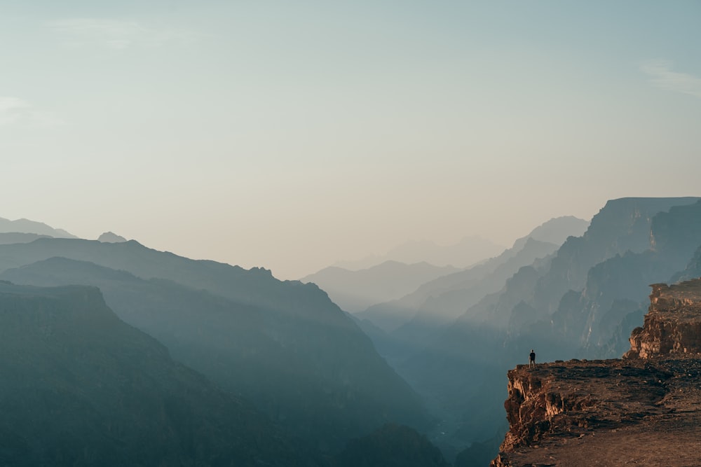 una persona in piedi sulla cima di una scogliera