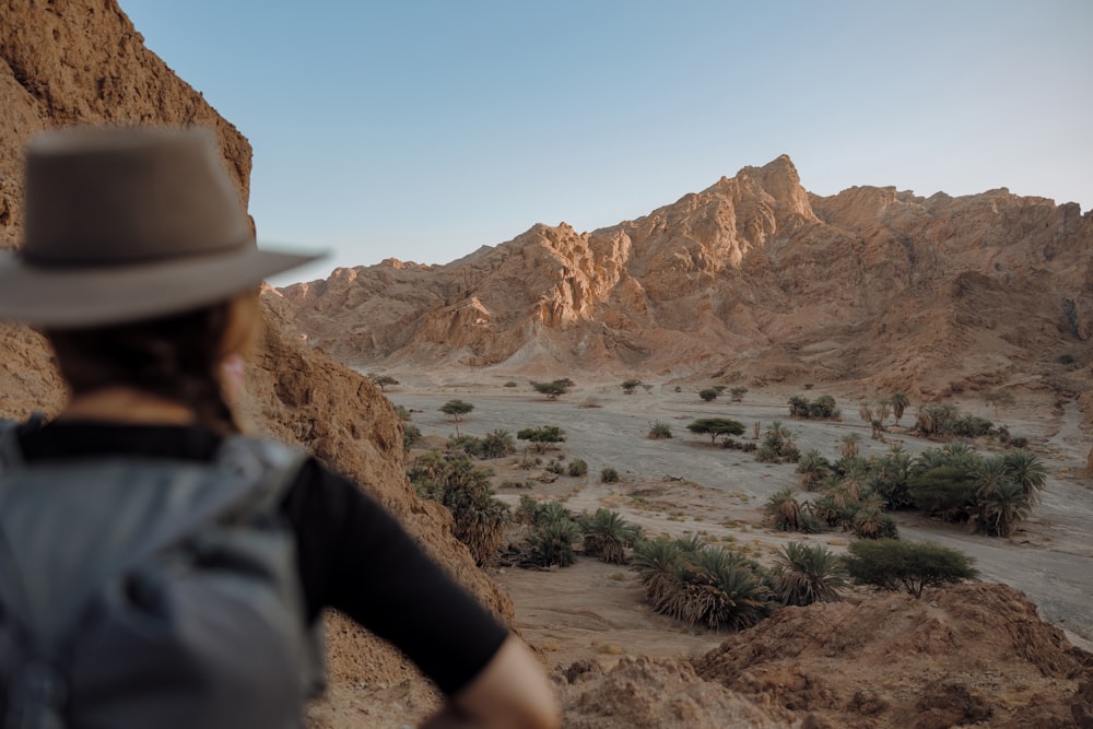 Une personne portant un chapeau regardant le désert