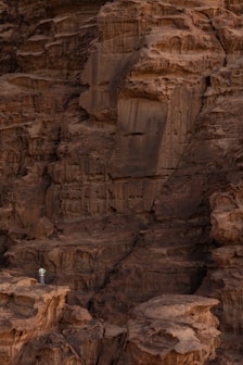 a person standing on a rock ledge in the desert