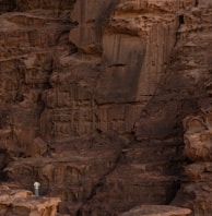 a person standing on a rock ledge in the desert