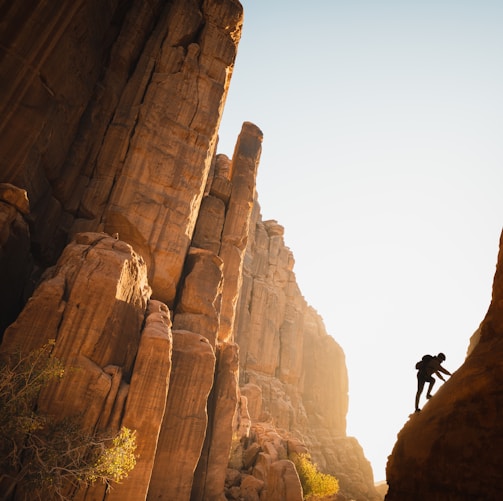 a man climbing up the side of a mountain