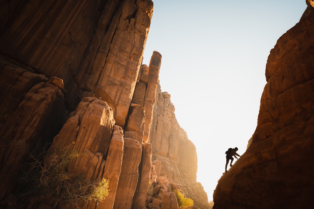 a man climbing up the side of a mountain