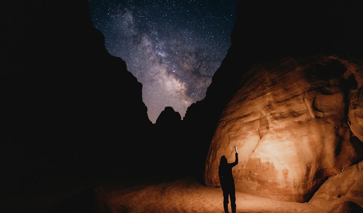 a man standing in the middle of a desert at night