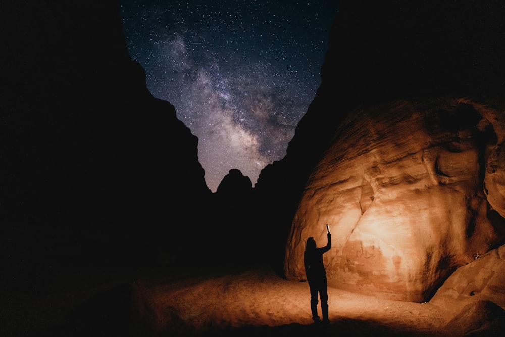 Ein Mann, der nachts mitten in einer Wüste steht