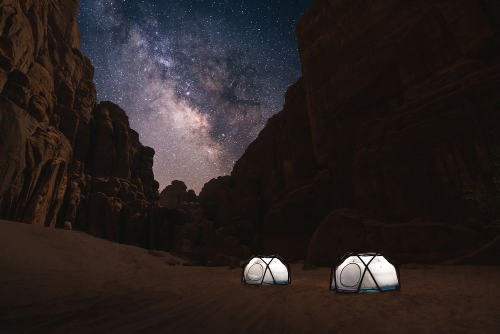 duas tendas montadas no deserto sob um céu noturno