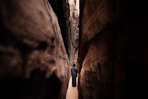 a man is walking through a narrow canyon