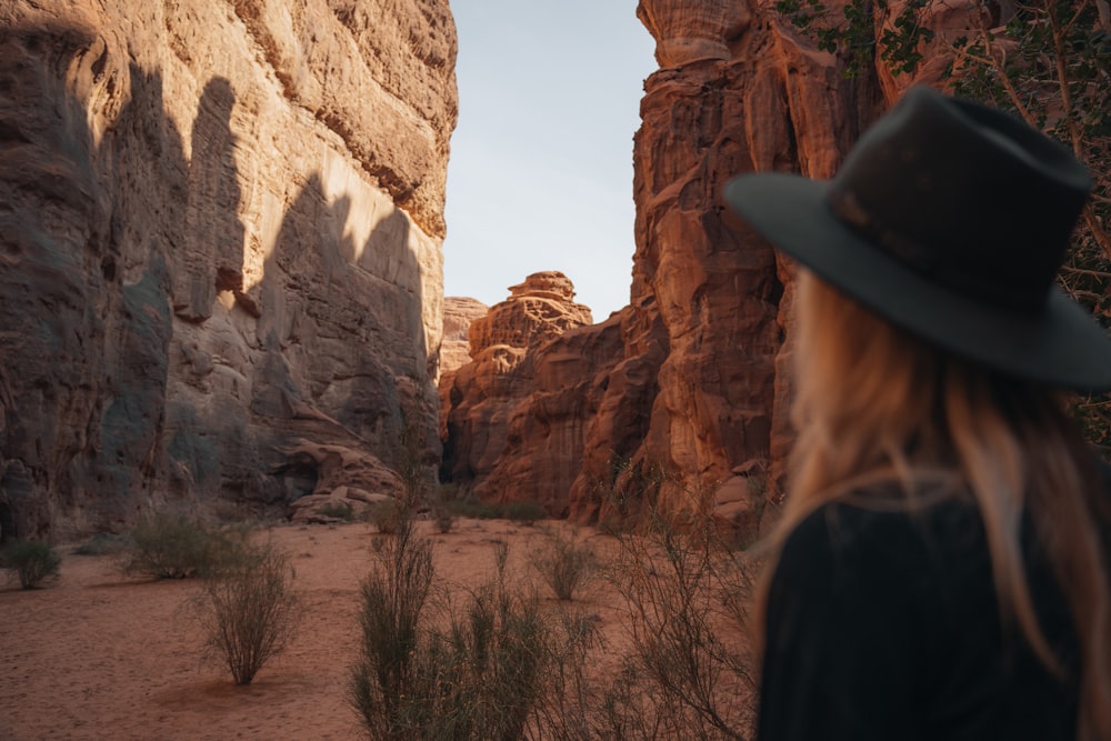 Una donna che indossa un cappello in piedi in un canyon