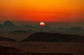 A warm sunset over the red desert with an event setup silhouette.
