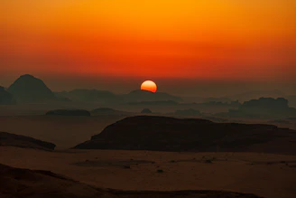 A warm sunset over a desert landscape with scattered homes.