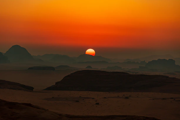 A warm sunset over a desert landscape with scattered homes.