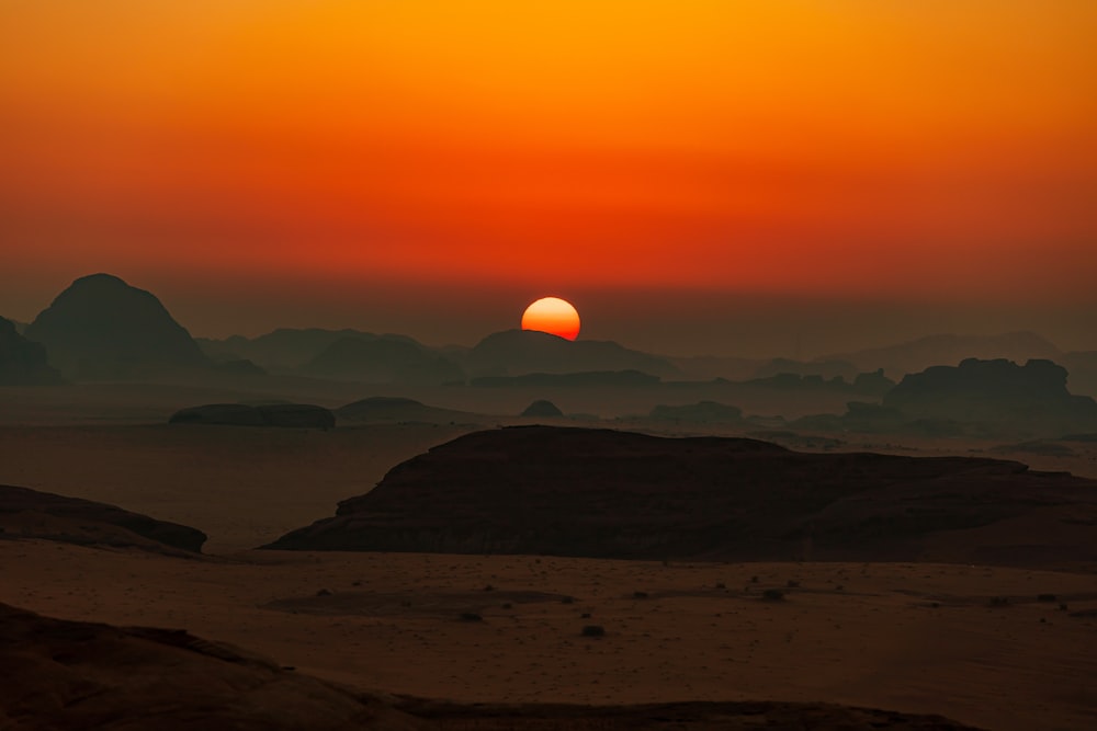 Le soleil se couche sur les montagnes dans le désert