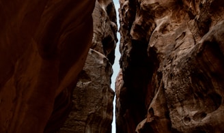 a person walking through a narrow slot in a canyon