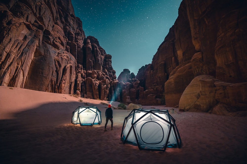 a man standing next to a tent in the desert