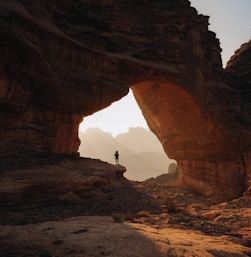 a person standing at the entrance to a cave