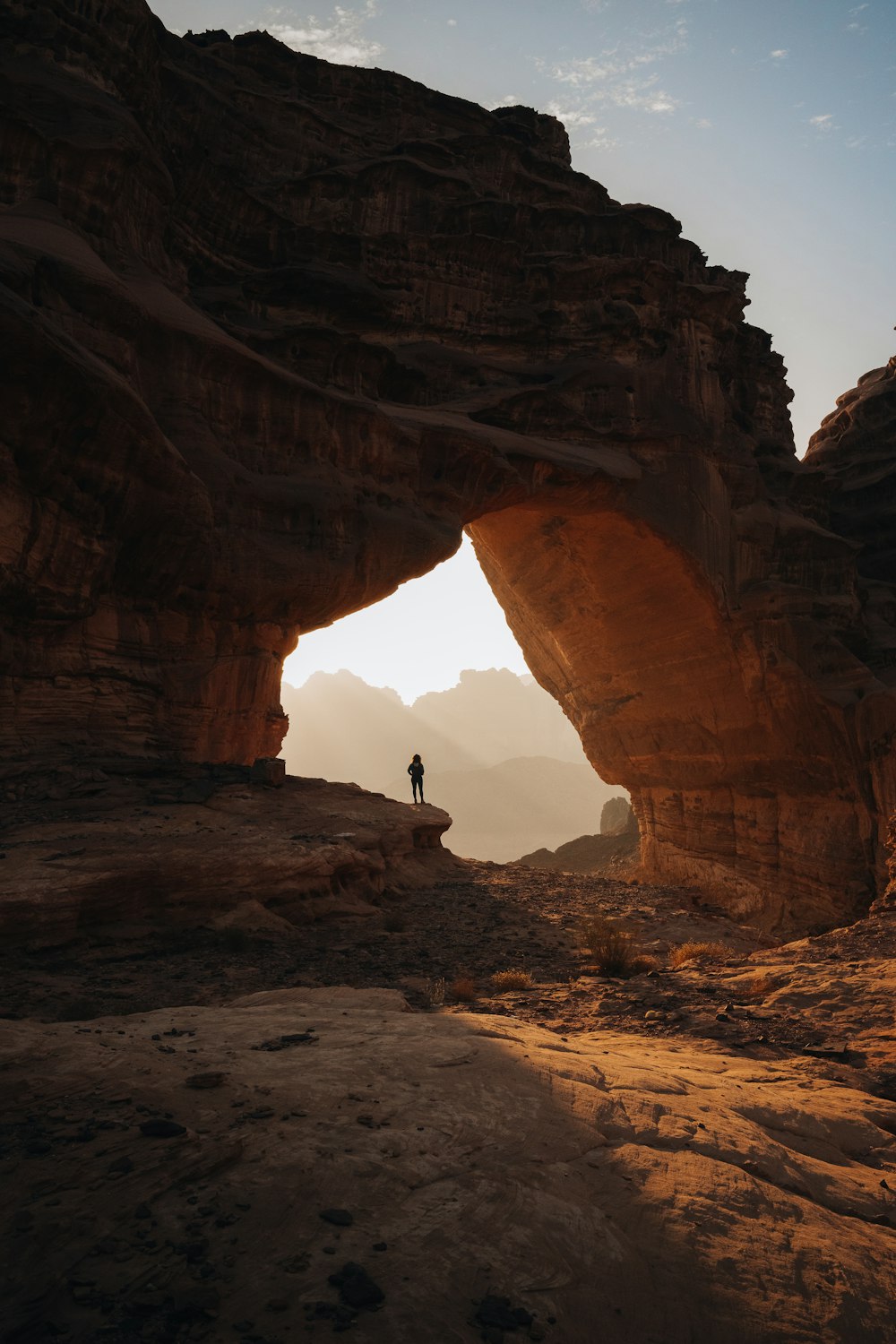 a person standing at the entrance to a cave