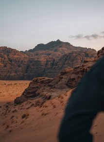 a man standing on top of a sandy hill