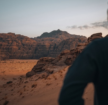 a man standing on top of a sandy hill