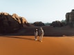 a man and a woman walking in the desert