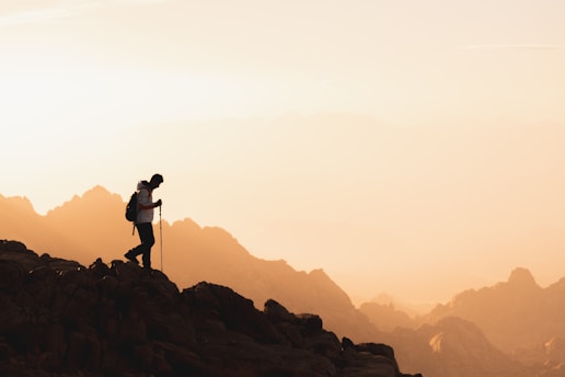 a couple of people standing on top of a mountain