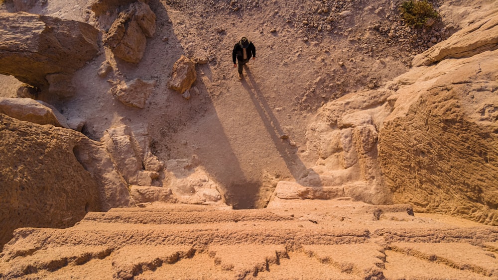 Due persone in piedi su una scogliera rocciosa si fronteggiano l'una con l'altra