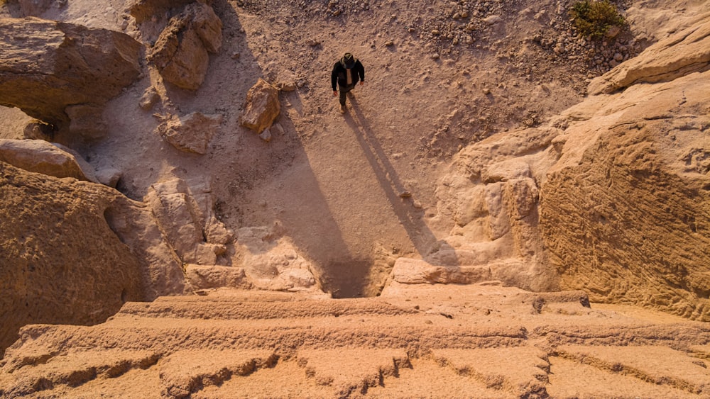 two people standing on a rocky cliff face each other