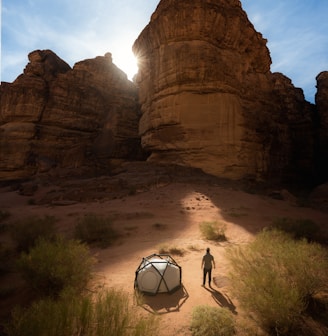 a man standing next to a tent in the desert