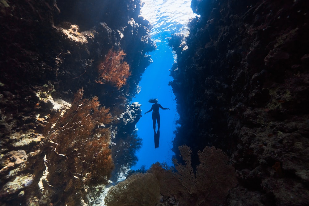 eine Person, die durch eine enge Unterwasserhöhle schwimmt