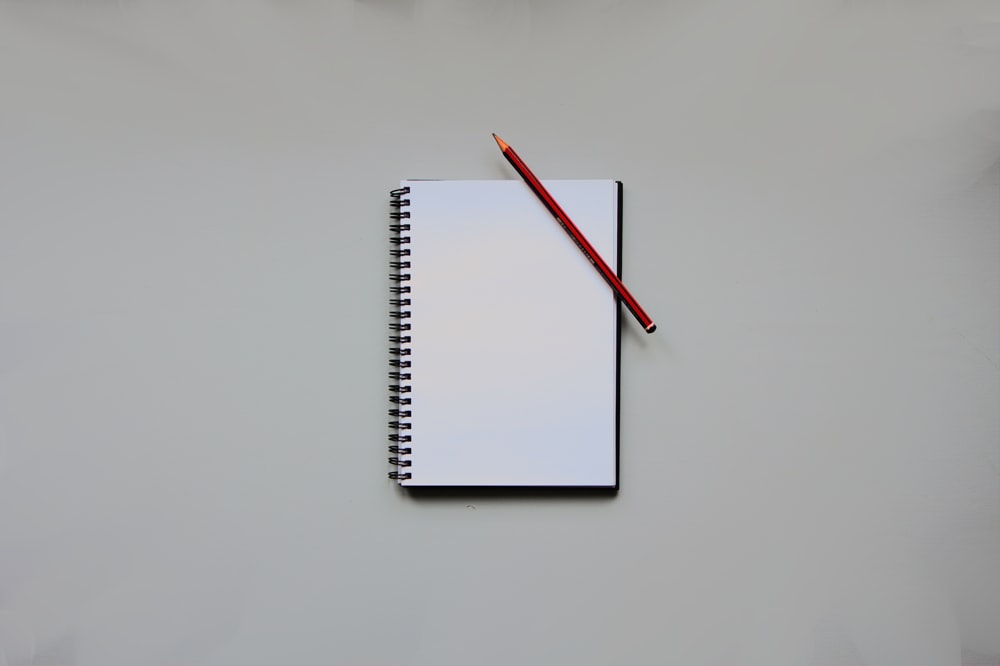 a notebook with a pencil on top of it