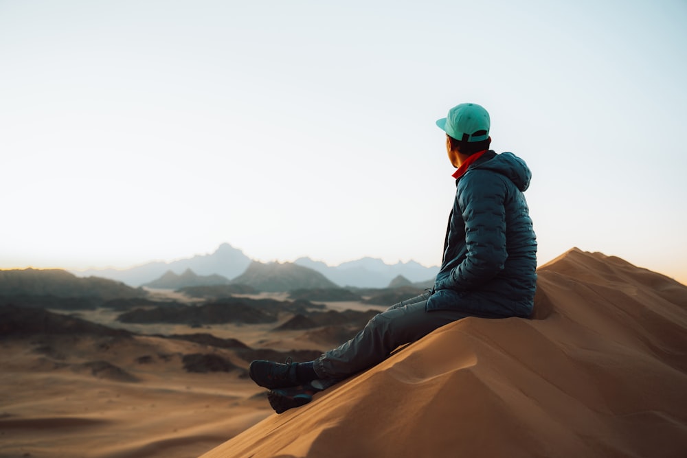 a person sitting on top of a sand dune