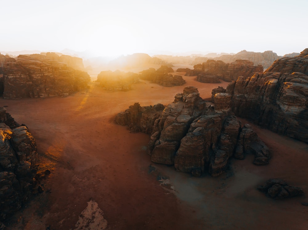 o sol está se pondo sobre uma paisagem rochosa